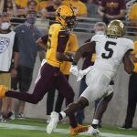 Arizona State quarterback Jayden Daniels (5) smiles at Colorado State safety Mark Perry (5) as he runs in for a touchdown during the first half of an NCAA college football game  Saturday, Sept 25, 2021, in Tempe, Ariz. (AP Photo/Darryl Webb)