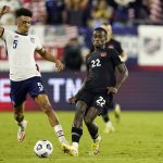 United States defender Antonee Robinson (5) and Canada defender Richie Laryea (22) battle for the ball during the second half of a World Cup soccer qualifier Sunday, Sept. 5, 2021, in Nashville, Tenn. (AP Photo/Mark Humphrey)