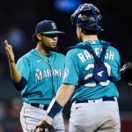 Seattle Mariners relief pitcher Yohan Ramirez, left, celebrates with catcher Cal Raleigh after the Mariners defeated the Arizona Diamondbacks 6-5 in 10 innings in a baseball game Friday, Sept. 3, 2021, in Phoenix. (AP Photo/Ross D. Franklin)