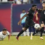 Canada forward Jonathan David, center, moves the pall past United States midfielder Christian Roldan, left, during the second half of a World Cup soccer qualifier Sunday, Sept. 5, 2021, in Nashville, Tenn. (AP Photo/Mark Humphrey)