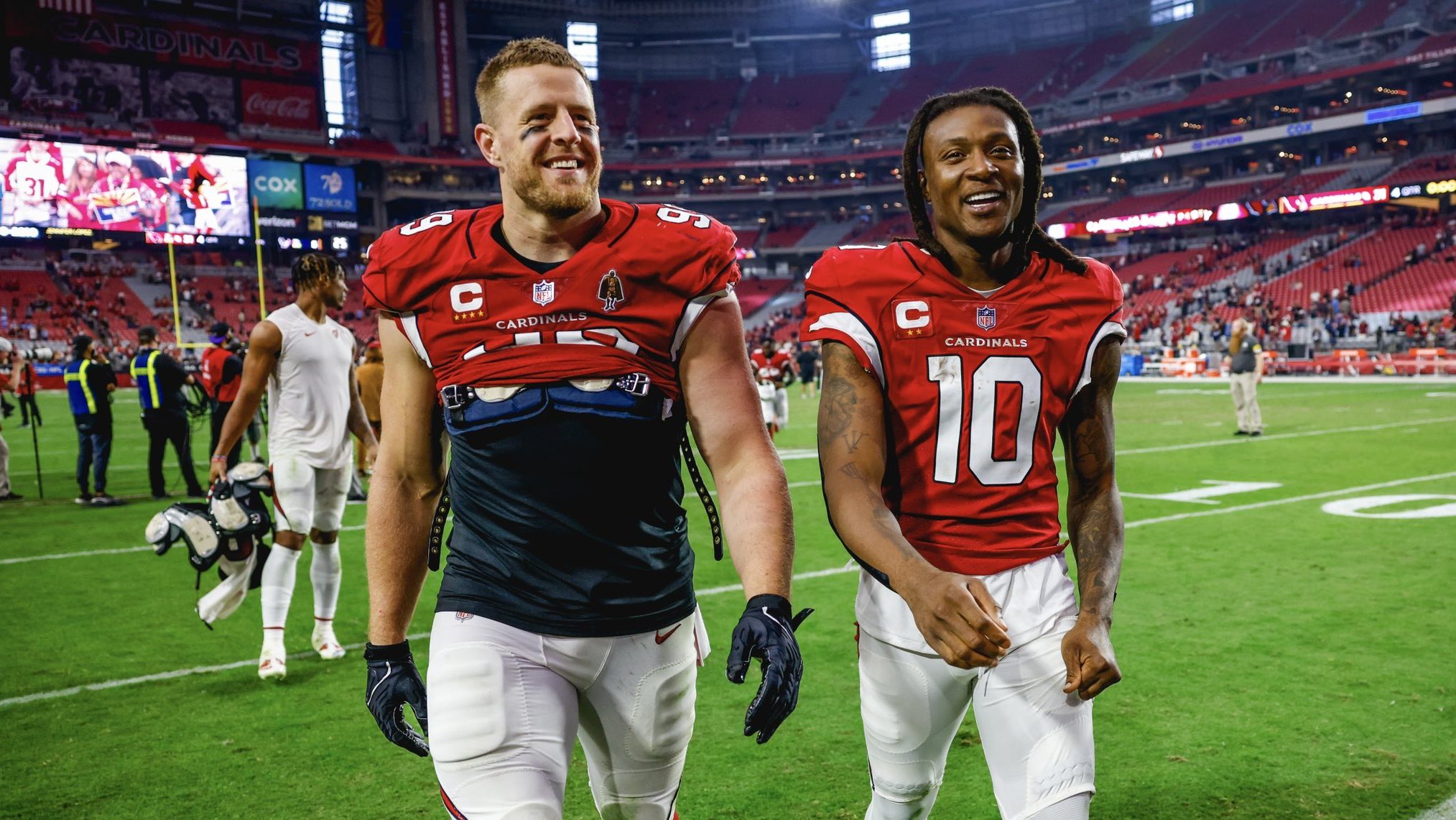 Arizona Cardinals DL J.J. Watt and WR DeAndre Hopkins leave the field after taking down the Houston...