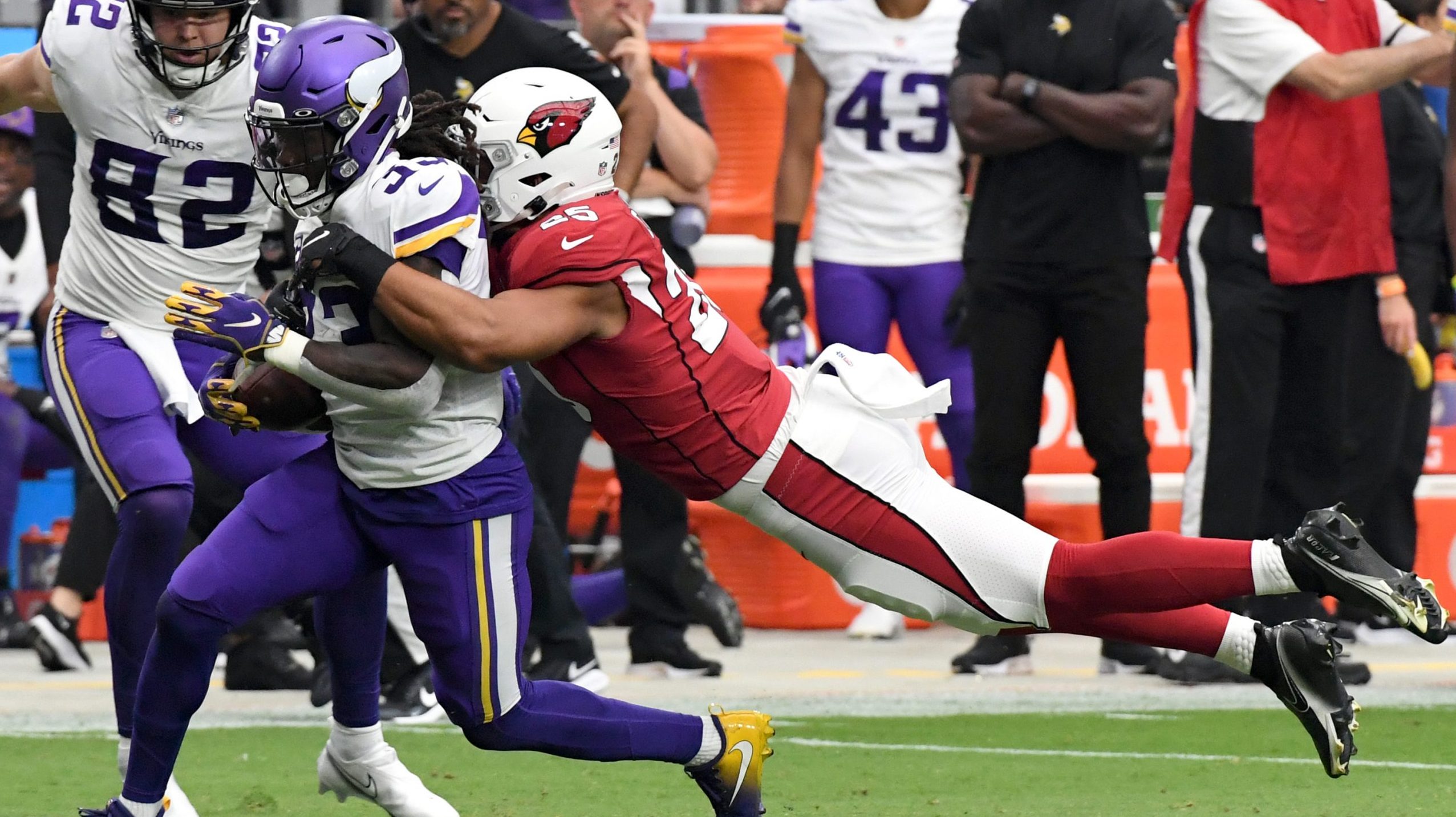 Zaven Collins #25 of the Arizona Cardinals tackles Dalvin Cook #33 of the Minnesota Vikings after C...