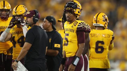 Quarterback Jayden Daniels #5 of the Arizona State Sun Devils watches from the sidelines during the...