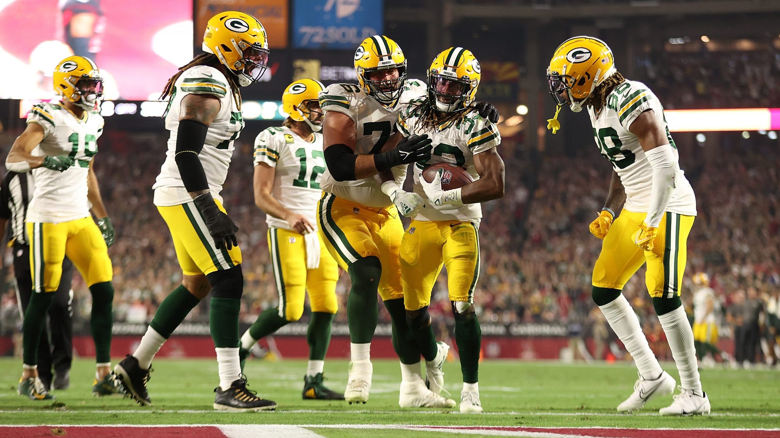 Aaron Jones #33 of the Green Bay Packers celebrates a touchdown with teammates during the first hal...