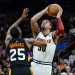 Denver Nuggets forward Aaron Gordon (50) shoots over Phoenix Suns forward Mikal Bridges (25) during the first half of an NBA basketball game, Wednesday, Oct. 20, 2021, in Phoenix. (AP Photo/Matt York)