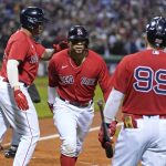 Boston Red Sox's Xander Bogaerts, middle, celebrates his two-run homer with Rafael Devers, left, and Alex Verdugo (99) in the first inning of the American League Wild Card playoff baseball game against the New York Yankees at Fenway Park, Tuesday Oct. 5, 2021, in Boston. (AP Photo/Charles Krupa)
