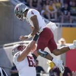Washington State lineman Carter Carlson (63) lifts his quarterback Jayden deLaura (4) in the air after deLaura threw a touchdown pass against Arizona State during the first half of an NCAA college football game, Saturday, Oct 30, 2021, in Tempe, Ariz. (AP Photo/Darryl Webb)