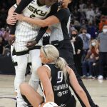 An official holds back Chicago Sky forward Kahleah Copper (2) above Phoenix Mercury guard Sophie Cunningham (9) during the first half of Game 2 of basketball's WNBA Finals, Wednesday, Oct. 13, 2021, in Phoenix. (AP Photo/Rick Scuteri)