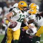 Green Bay Packers quarterback Aaron Rodgers (12) pushes down Arizona Cardinals linebacker Markus Golden (44) during the first half of an NFL football game, Thursday, Oct. 28, 2021, in Glendale, Ariz. (AP Photo/Ross D. Franklin)