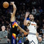 Denver Nuggets guard Facundo Campazzo (7) dishes over his shoulder as Phoenix Suns guard Landry Shamet defends during the first half of an NBA basketball game, Wednesday, Oct. 20, 2021, in Phoenix. (AP Photo/Matt York)