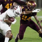 Stanford running back Nathaniel Peat tries to to fend off Arizona State defensive back Chase Lucas (24) as Arizona State defensive back Evan Fields (4) watches during the first half of an NCAA college football game Friday, Oct. 8, 2021, in Tempe, Ariz. (AP Photo/Ross D. Franklin)