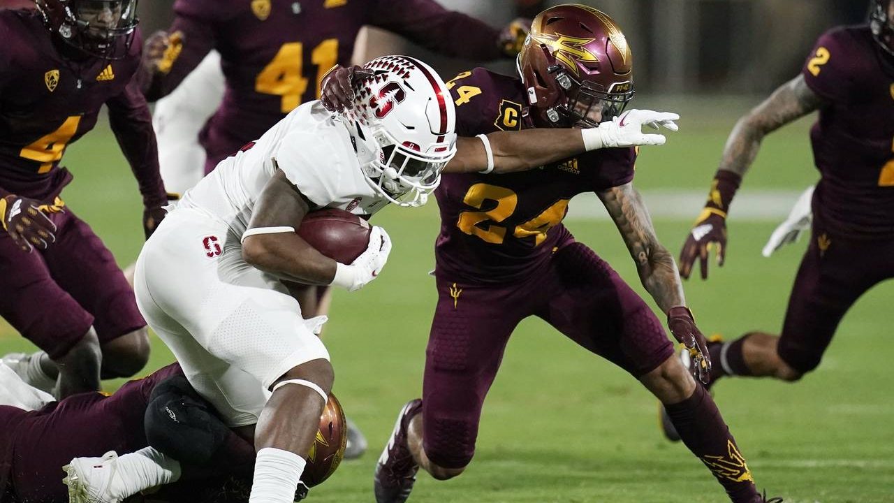 Stanford running back Nathaniel Peat tries to to fend off Arizona State defensive back Chase Lucas ...