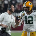 Green Bay Packers head coach Matt LaFleur talks with quarterback Aaron Rodgers (12) during the first half of an NFL football game against the Arizona Cardinals, Thursday, Oct. 28, 2021, in Glendale, Ariz. (AP Photo/Rick Scuteri)