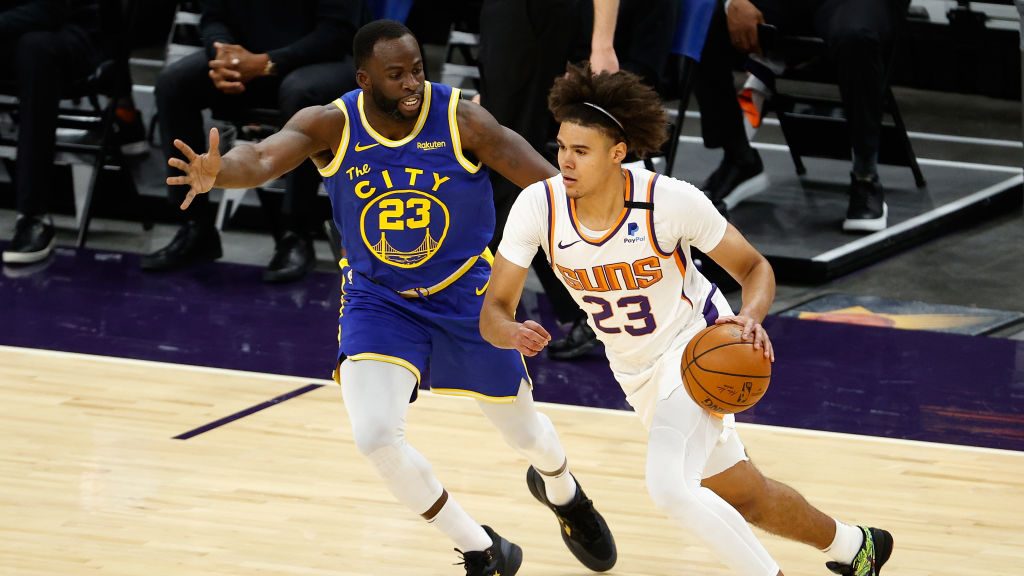 Cameron Johnson #23 of the Phoenix Suns drives the ball past Draymond Green #23 of the Golden State...