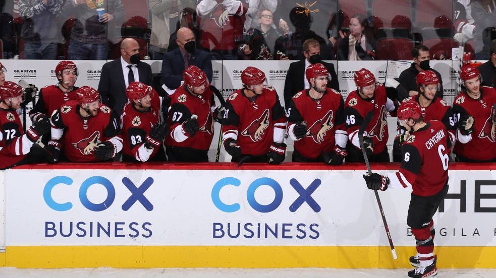 Jakob Chychrun #6 of the Arizona Coyotes high fives teammates on the bench after scoring a shootout...