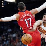 Phoenix Suns guard Devin Booker, right, gets off a pass around New Orleans Pelicans center Jonas Valanciunas (17) during the first half of an NBA basketball game Tuesday, Nov. 2, 2021, in Phoenix. (AP Photo/Ross D. Franklin)
