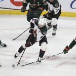 Arizona Coyotes right wing Clayton Keller (9) controls the puck next to Minnesota Wild left wing Jordan Greenway (18) during the first period of an NHL hockey game Tuesday, Nov. 30, 2021, in St. Paul, Minn. (AP Photo/Stacy Bengs)