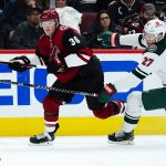 Arizona Coyotes right wing Christian Fischer (36) and Minnesota Wild center Nick Bjugstad (27) skate after the puck during the second period of an NHL hockey game Wednesday, Nov. 10, 2021, in Glendale, Ariz. The Wild won 5-2. (AP Photo/Ross D. Franklin)