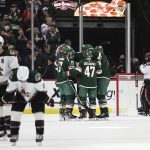 Minnesota Wild players celebrate around left wing Jordan Greenway after he scored a goal against the Arizona Coyotes during the second period of an NHL hockey game Tuesday, Nov. 30, 2021, in St. Paul, Minn. (AP Photo/Stacy Bengs)