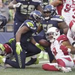 Seattle Seahawks' DeeJay Dallas, center, tosses aside the ball as he gets up from the pile after scoring a touchdown against the Arizona Cardinals during the second half of an NFL football game, Sunday, Nov. 21, 2021, in Seattle. (AP Photo/Ted S. Warren)