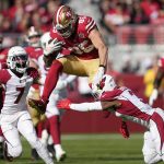 San Francisco 49ers tight end George Kittle, top, jumps against Arizona Cardinals cornerback Byron Murphy Jr. (7) and safety Budda Baker, bottom, before fumbling the ball, which was recovered by the Cardinals, during the first half of an NFL football game in Santa Clara, Calif., Sunday, Nov. 7, 2021. (AP Photo/Tony Avelar)
