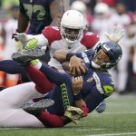 Seattle Seahawks quarterback Russell Wilson (3) is sacked by Arizona Cardinals' Chandler Jones, bottom, as Cardinals' Markus Golden (44) moves in on top during the second half of an NFL football game, Sunday, Nov. 21, 2021, in Seattle. (AP Photo/Ted S. Warren)