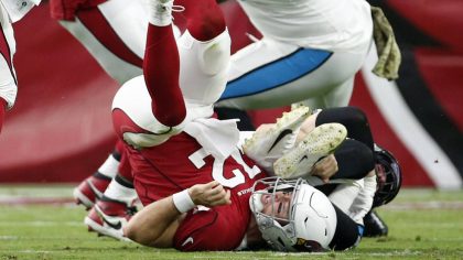 Arizona Cardinals quarterback Colt McCoy flips over after fumbling the ball to the Carolina Panther...