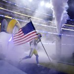 Los Angeles Rams wide receiver Van Jefferson carries a flag as part of the league's Salute to Service before an NFL football game against the Tennessee Titans, Sunday, Nov. 7, 2021, in Inglewood, Calif. (AP Photo/Marcio Jose Sanchez)