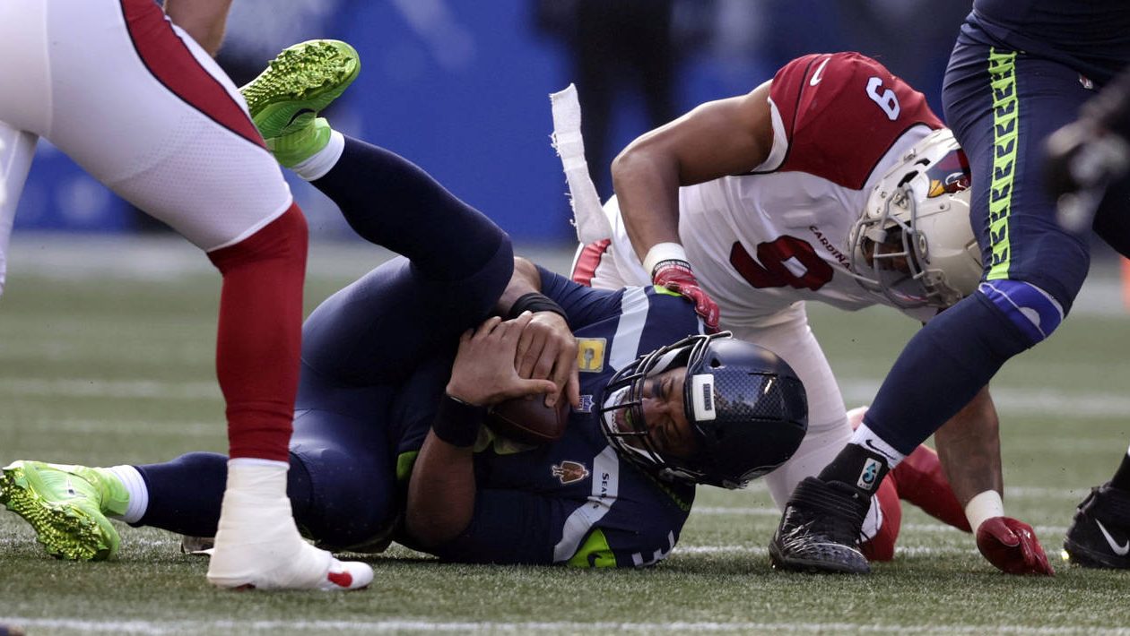 Seattle Seahawks quarterback Russell Wilson, bottom left, is sacked by Arizona Cardinals' Isaiah Si...