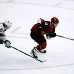 Arizona Coyotes defenseman Shayne Gostisbehere (14) skates with the puck in front of Minnesota Wild left wing Kirill Kaprizov (97) during the third period of an NHL hockey game Wednesday, Nov. 10, 2021, in Glendale, Ariz. The Wild won 5-2. (AP Photo/Ross D. Franklin)