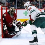 Arizona Coyotes goaltender Karel Vejmelka, left, makes a save on a shot by Minnesota Wild right wing Ryan Hartman (38) during the second period of an NHL hockey game Wednesday, Nov. 10, 2021, in Glendale, Ariz. (AP Photo/Ross D. Franklin)