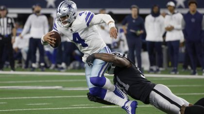 Dallas Cowboys quarterback Dak Prescott (4) is stopped as he runs the ball by Las Vegas Raiders def...