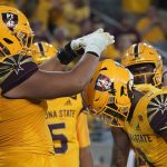 Arizona State running back Rachaad White (3) gets crowned by his offensive lineman Dohnovan West (61) after scoring a touchdown against Southern California during the second half of an NCAA college football game Saturday, Nov. 6, 2021, in Tempe, Ariz. (AP Photo/Darryl Webb)