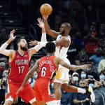 Phoenix Suns guard Chris Paul, right, passes the ball to a teammate over New Orleans Pelicans guard Nickeil Alexander-Walker (6) and center Jonas Valanciunas (17) during the second half of an NBA basketball game Tuesday, Nov. 2, 2021, in Phoenix. The Suns won 112-100. (AP Photo/Ross D. Franklin)
