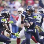 Seattle Seahawks quarterback Russell Wilson, right, hands off to running back Alex Collins against the Arizona Cardinals during the first half of an NFL football game, Sunday, Nov. 21, 2021, in Seattle. (AP Photo/Ted S. Warren)
