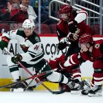 Minnesota Wild center Joel Eriksson Ek (14) battles with Arizona Coyotes center Barrett Hayton (29) and Coyotes right wing Phil Kessel, second from right, for the puck during the second period of an NHL hockey game Wednesday, Nov. 10, 2021, in Glendale, Ariz. The Wild won 5-2. (AP Photo/Ross D. Franklin)
