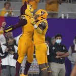 Arizona State running back Rachaad White (3) chest bumps Sun Devil mascot Sparky after scoring a touchdown against Southern California during the second half of an NCAA college football game Saturday, Nov. 6, 2021, in Tempe, Ariz. (AP Photo/Darryl Webb)