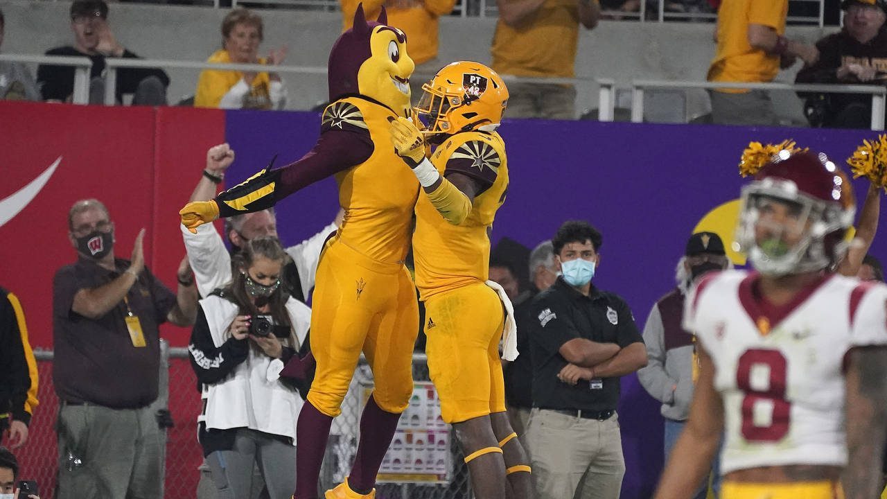 Arizona State running back Rachaad White (3) chest bumps Sun Devil mascot Sparky after scoring a to...