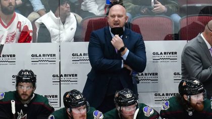 Arizona Coyotes head coach André Tourigny shouts instructions to his players on the ice as he stan...