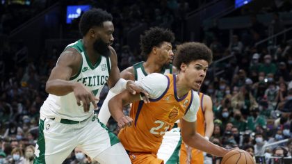 Phoenix Suns forward Cameron Johnson (23) drives between Boston Celtics guard Jaylen Brown (7) and ...