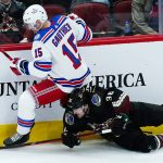 New York Rangers right wing Julien Gauthier (15) sends Arizona Coyotes right wing Christian Fischer (36) to the ice during the first period of an NHL hockey game Wednesday, Dec. 15, 2021, in Glendale, Ariz. (AP Photo/Ross D. Franklin)