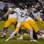 West Virginia quarterback Jarret Doege (2) throws a pass against Minnesota during the first half of the Guaranteed Rate Bowl NCAA college football game Tuesday, Dec. 28, 2021, in Phoenix. (AP Photo/Rick Scuteri)