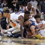 Memphis Grizzlies guard John Konchar, bottom, and forward Brandon Clarke, left, compete for the loose ball with Phoenix Suns forward Jalen Smith (10), forward Cameron Johnson, right, and guard Chris Paul, top, during the second half of an NBA basketball game Monday, Dec. 27, 2021, in Phoenix. The Grizzlies won 114-113. (AP Photo/Rick Scuteri)