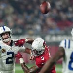 Indianapolis Colts quarterback Carson Wentz (2) throws to tight end Mo Alie-Cox (81) under pressure from Arizona Cardinals inside linebacker Isaiah Simmons (9) during the second half of an NFL football game, Saturday, Dec. 25, 2021, in Glendale, Ariz. (AP Photo/Ross D. Franklin)