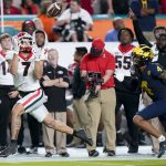 Georgia wide receiver Jermaine Burton catches a touchdown pass in front of Michigan defensive back Vincent Gray during the first half of the Orange Bowl NCAA College Football Playoff semifinal game, Friday, Dec. 31, 2021, in Miami Gardens, Fla. (AP Photo/Lynne Sladky)