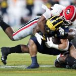 Michigan running back Blake Corum is tackled by Georgia defensive lineman Travon Walker during the first half of the Orange Bowl NCAA College Football Playoff semifinal game, Friday, Dec. 31, 2021, in Miami Gardens, Fla. (AP Photo/Lynne Sladky)