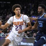 Phoenix Suns forward Cameron Johnson (23) drives on Memphis Grizzlies forward Jaren Jackson Jr. during the first half of an NBA basketball game Monday, Dec. 27, 2021, in Phoenix. (AP Photo/Rick Scuteri)