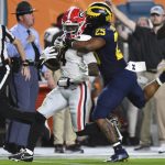 Georgia running back James Cook is tackled by Michigan linebacker Junior Colson during the first half of the Orange Bowl NCAA College Football Playoff semifinal game, Friday, Dec. 31, 2021, in Miami Gardens, Fla. (AP Photo/Jim Rassol)