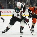 Arizona Coyotes right wing Christian Fischer (36) controls the puck against Anaheim Ducks defenseman Kevin Shattenkirk (22) and defenseman Cam Fowler (4) during the third period of an NHL hockey game in Anaheim, Calif., Friday, Dec. 17, 2021. (AP Photo/Ashley Landis)