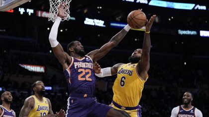 Los Angeles Lakers' LeBron James, right, shoots against Phoenix Suns' Deandre Ayton during second h...